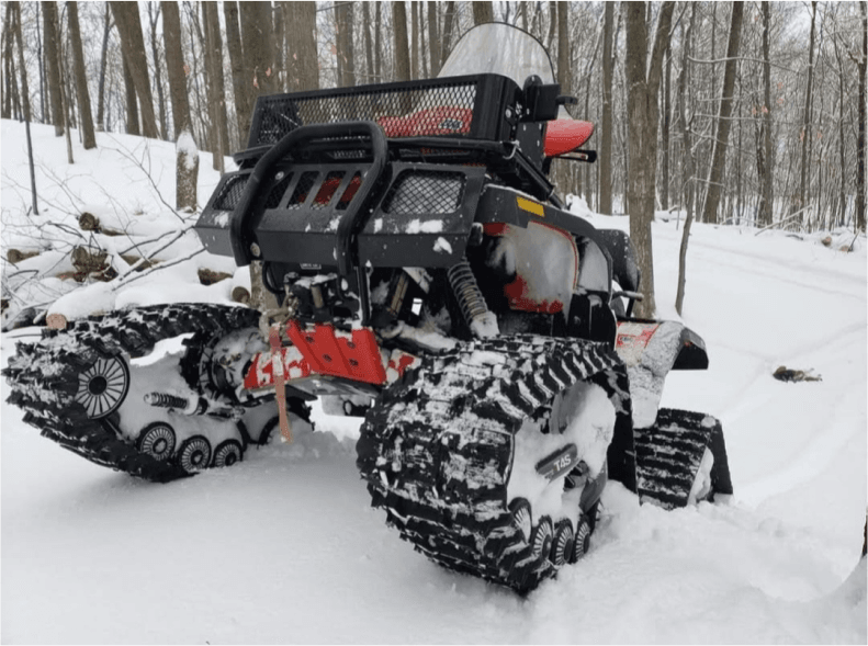 ATV with track conversion kit in snowy woods