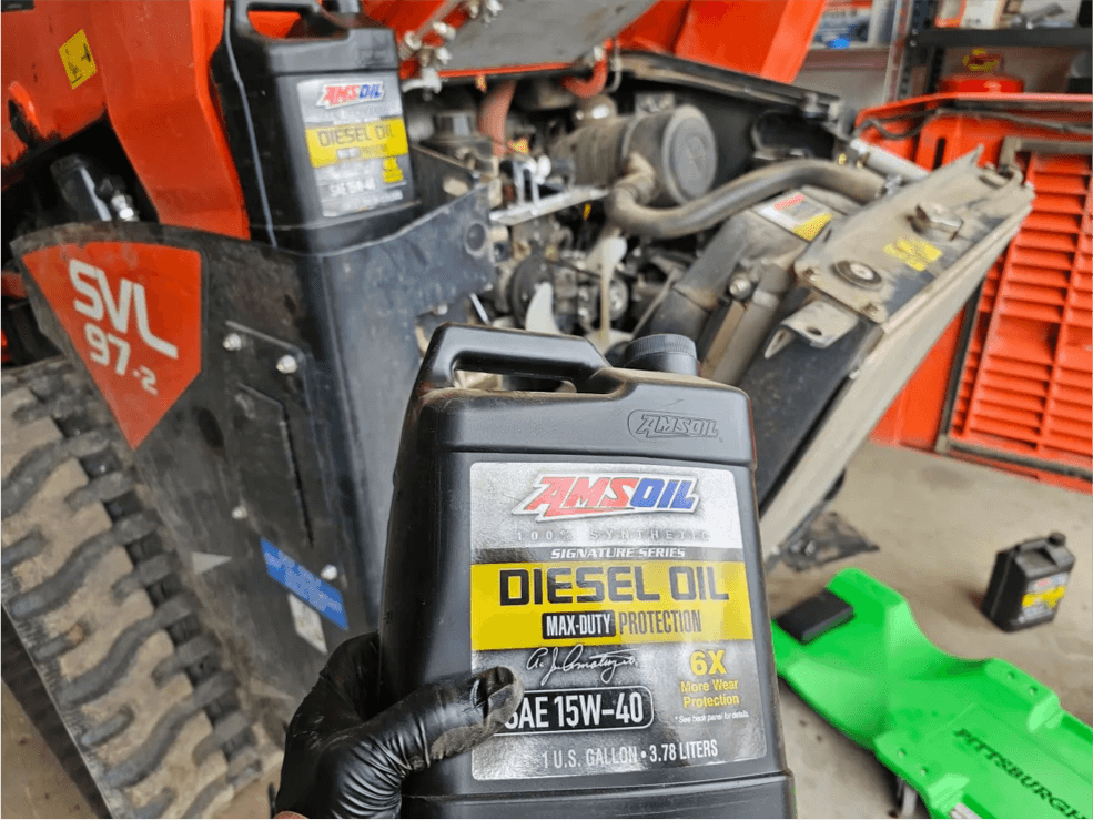 AMSOIL Diesel Oil and Severe Gear products next to Kubota equipment