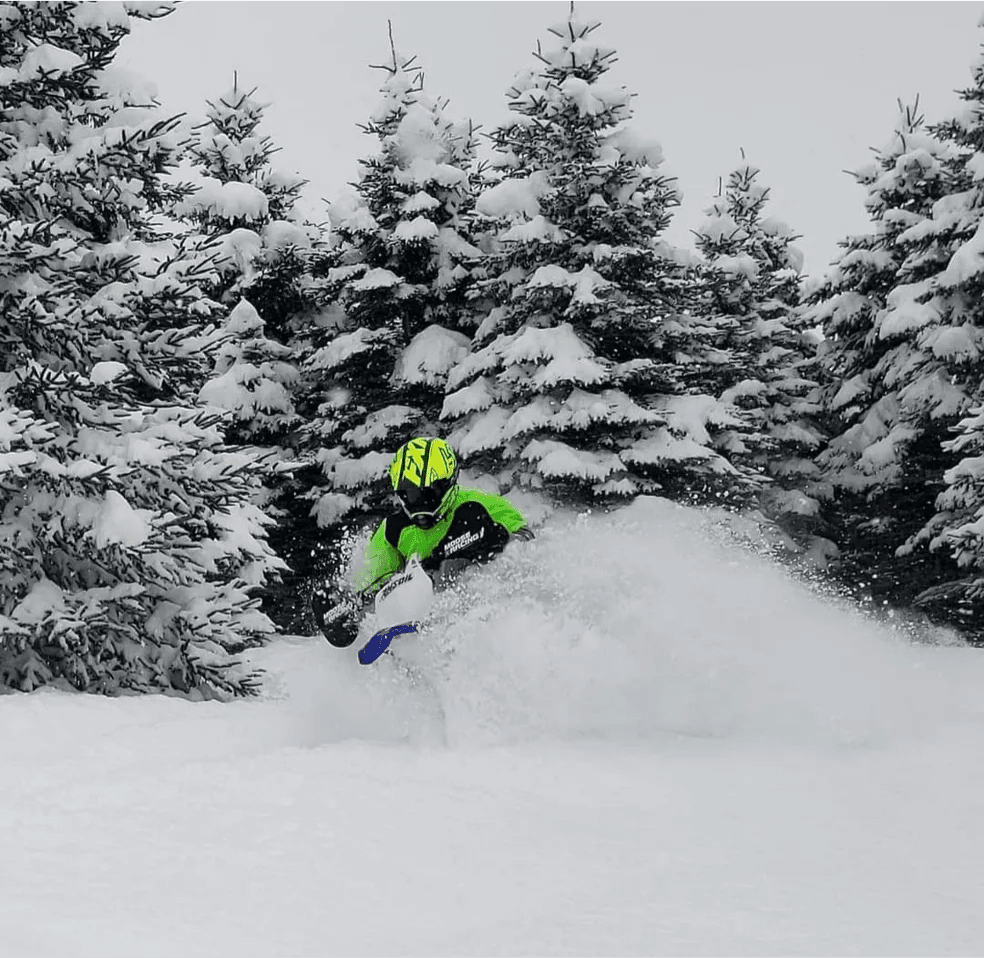 Snowmobile rider blasting through deep powder snow