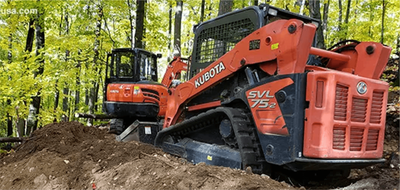 Kubota track loader and mini excavator working in a wooded area