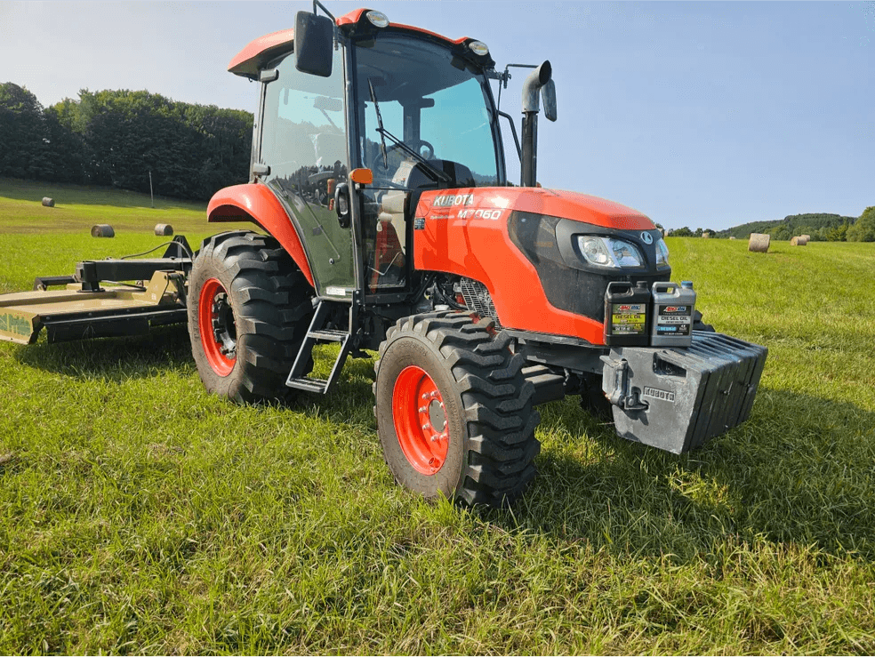 Orange Kubota tractor parked on a grassy field