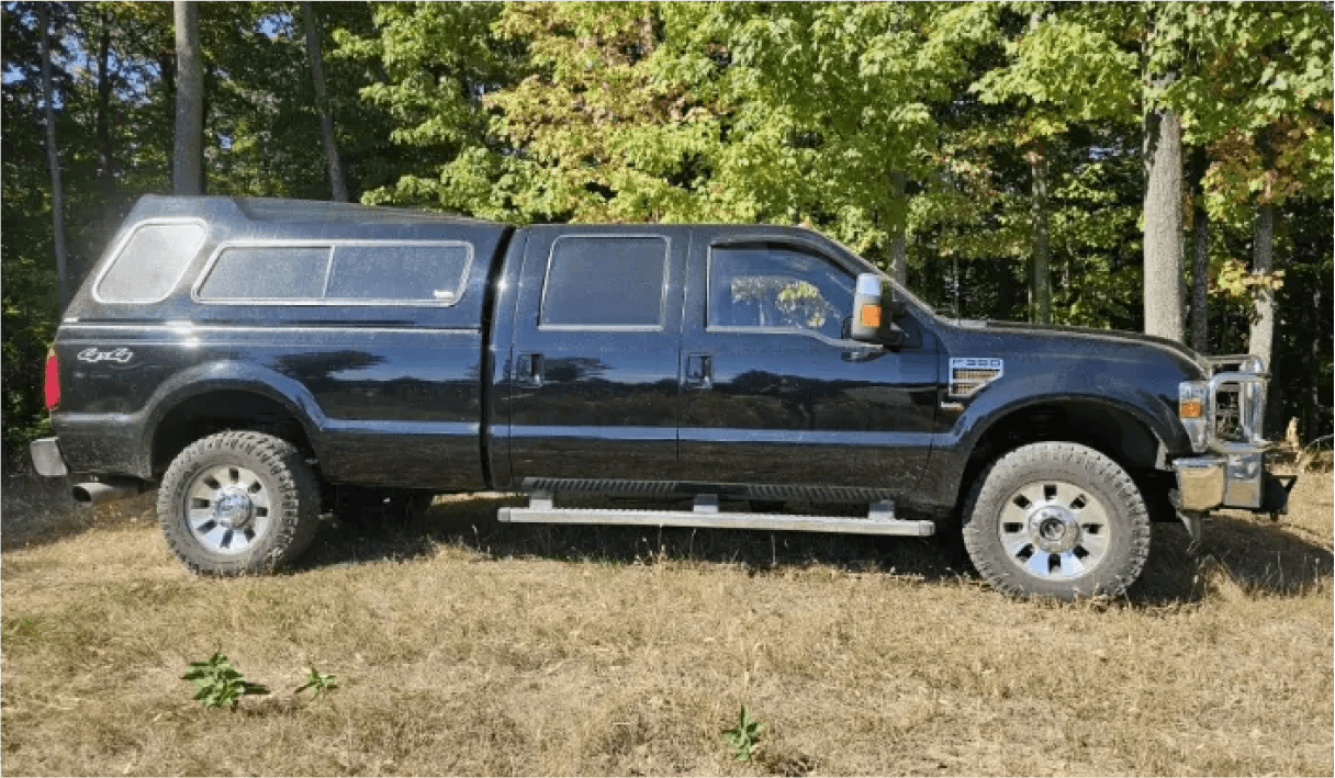 Black Ford Super Duty 4x4 with camper shell